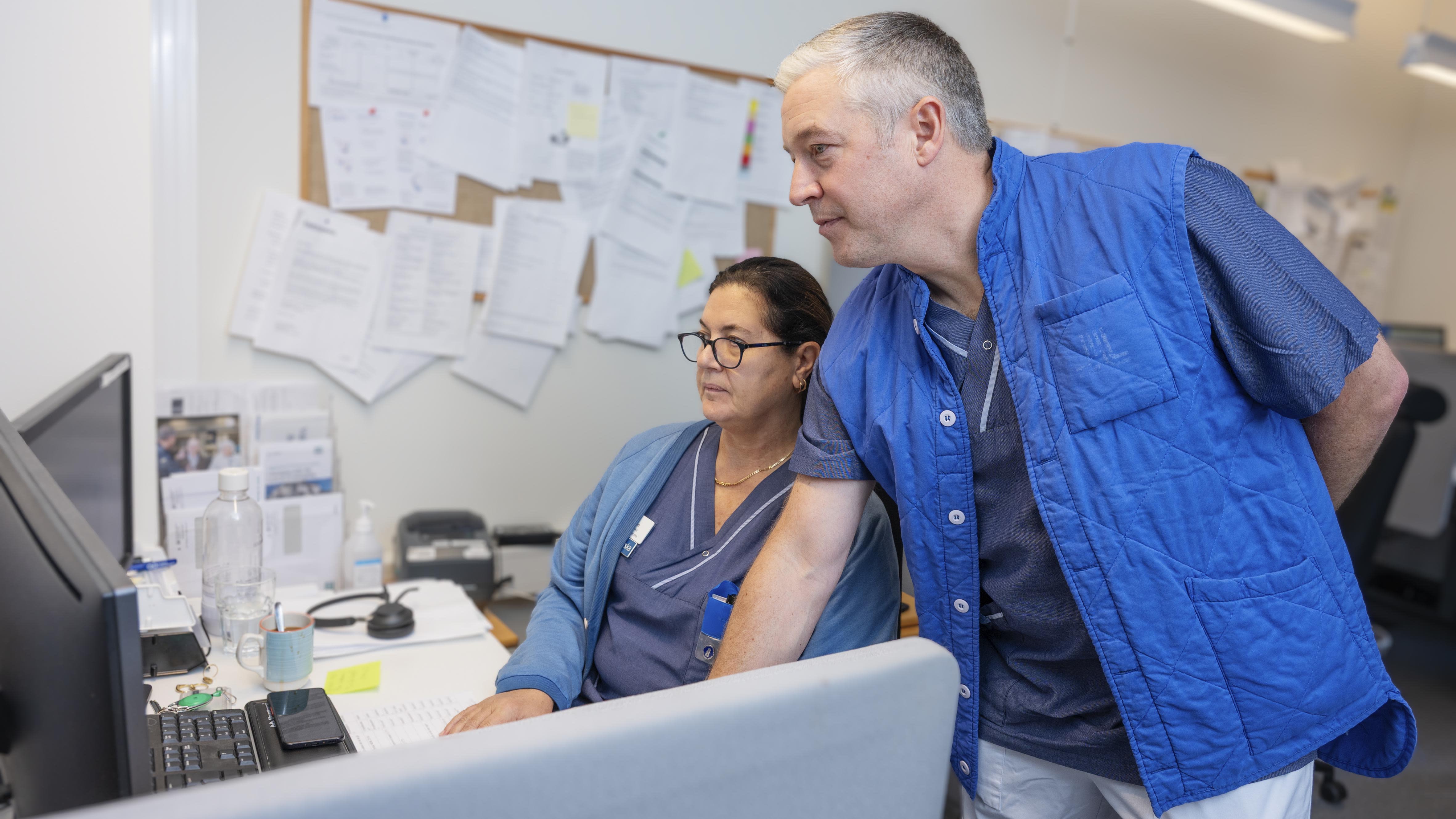 två vårdpersonal ser på dator