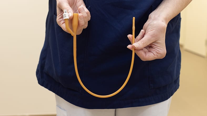 Sjukvårdspersonal håller i urinkateter