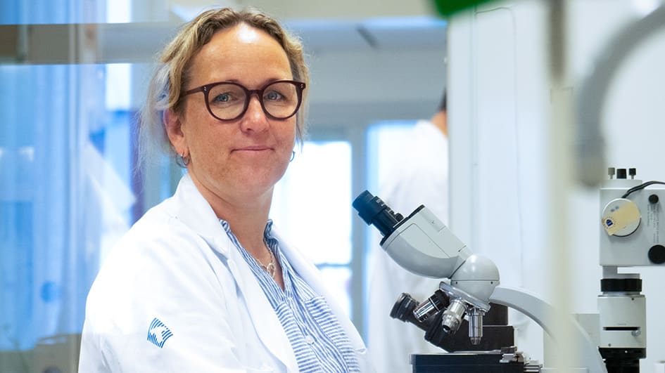 Malin Sund i ett labb vid ett mikroskåp
