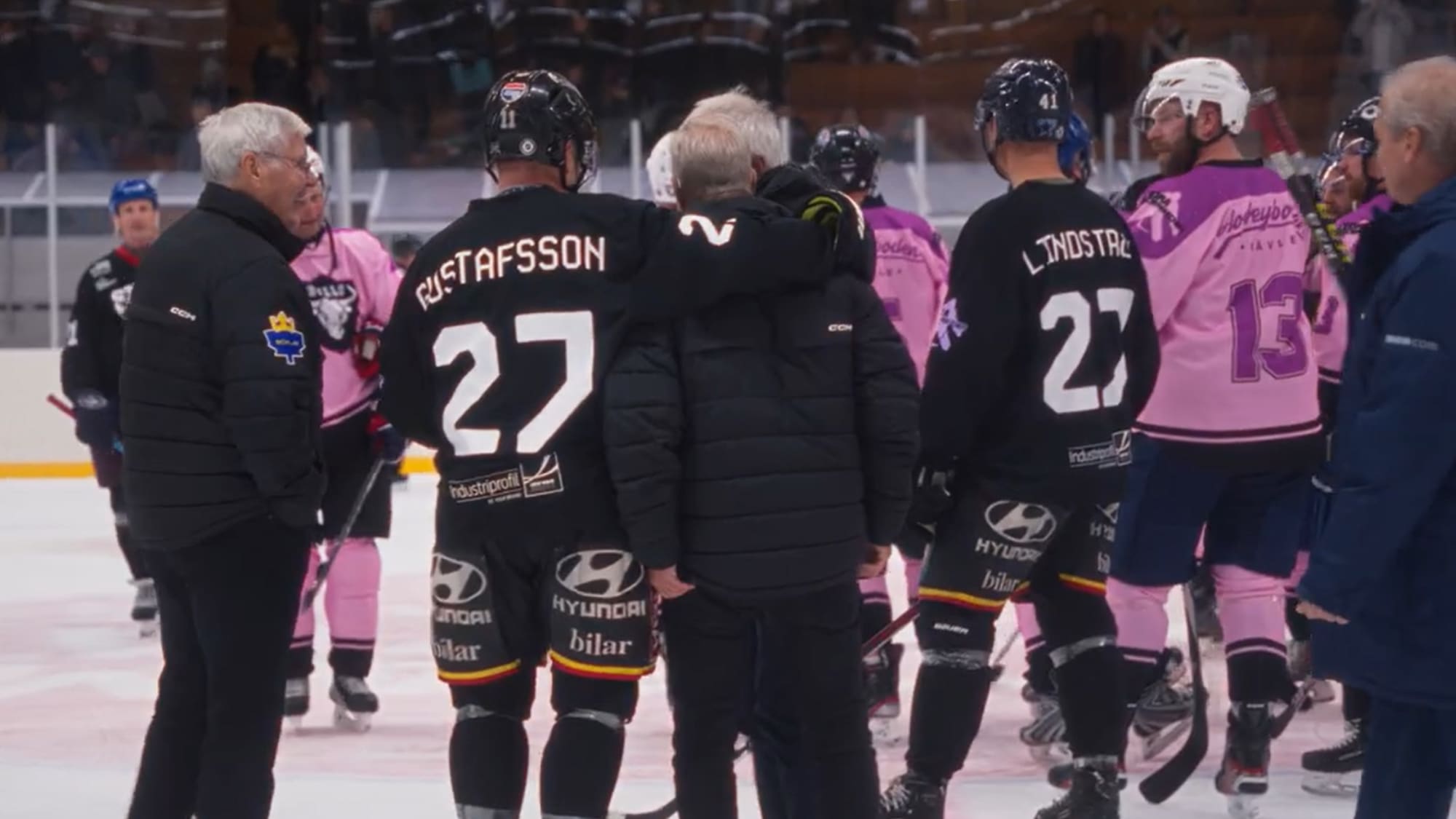 Efter slutsignal. Hockeyspelare håller armen om coach. 