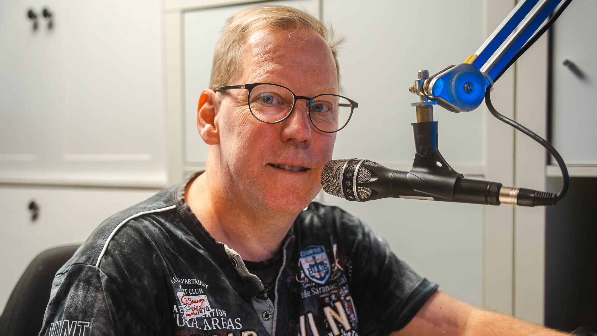 En man sitter vid en mikrofon 