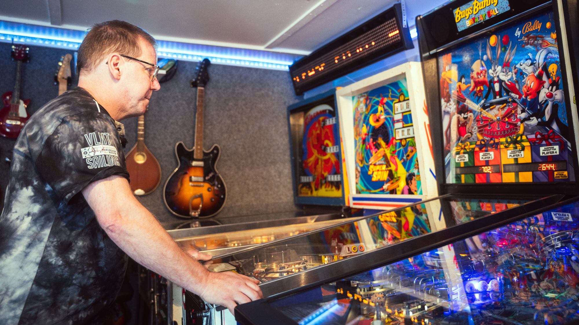 En man står och spelar flipperspel 