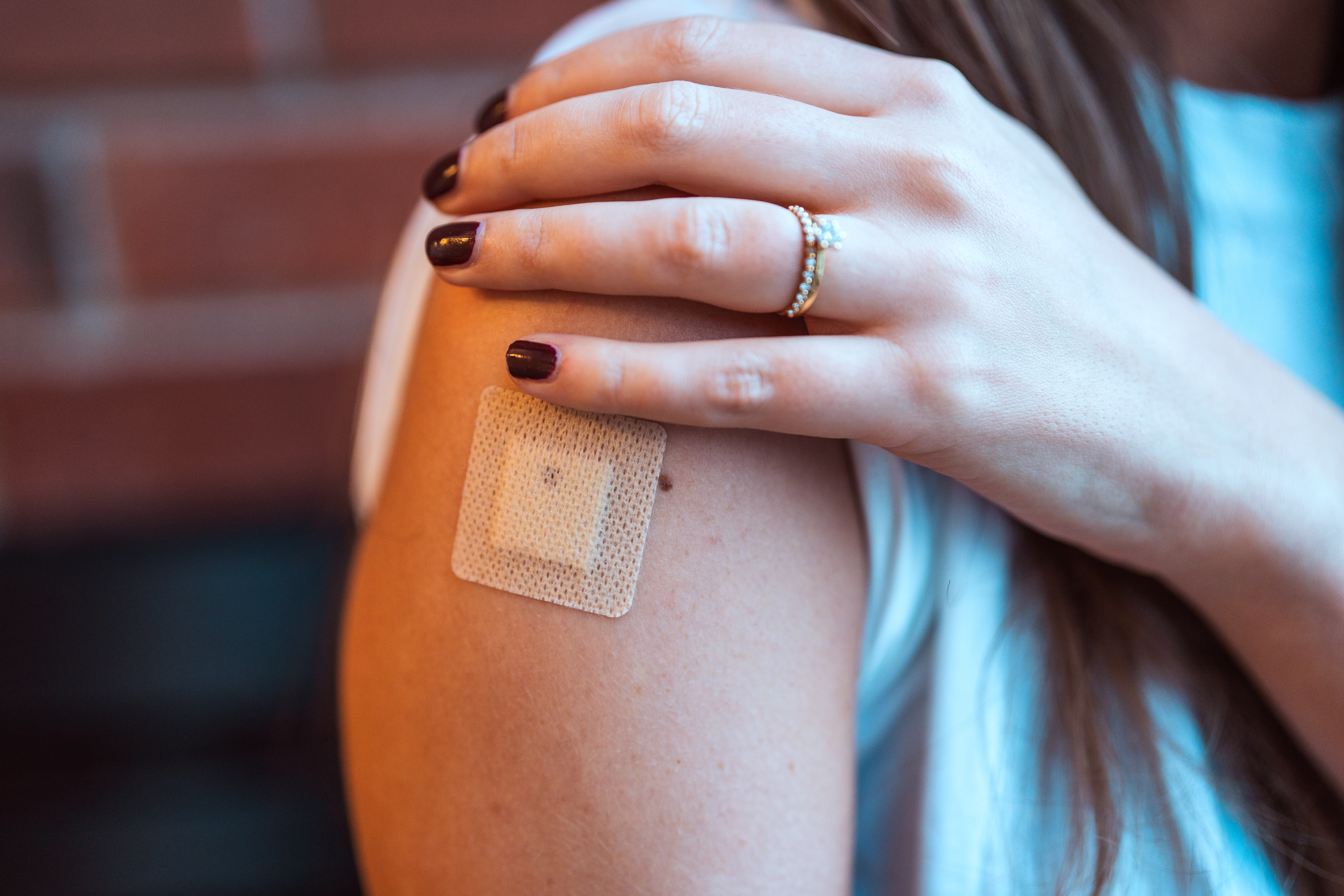 Tjej visar axeln där hon tagit HPV-vaccin