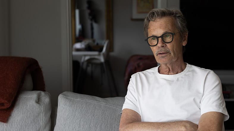 Medelålders man i soffa med glasögon