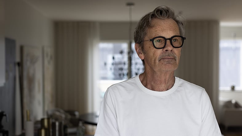 Man i glasögon framför fönster