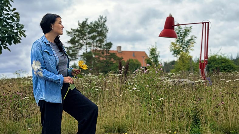 Kvinna med blomma i handen.