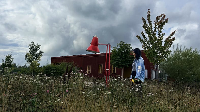 Kvinna gående på fält med blommor