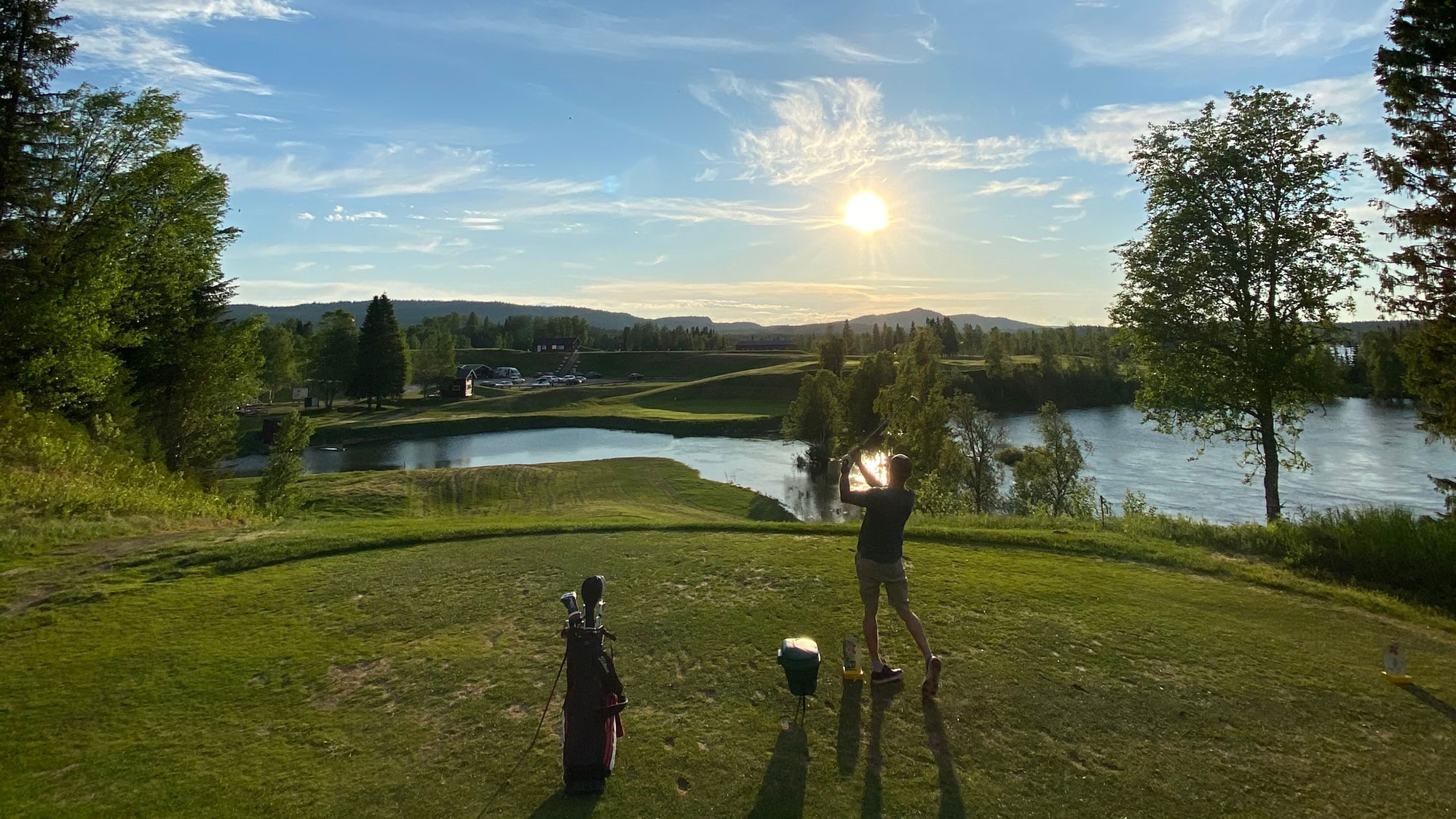 Man på golfbana i solnedgång