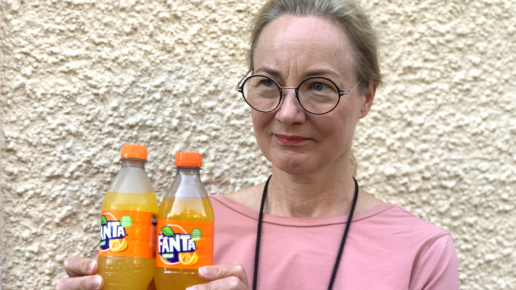 Cancerfondens generalsekreterare Ulrika Årehed Kågström håller upp två flaskor med fanta.