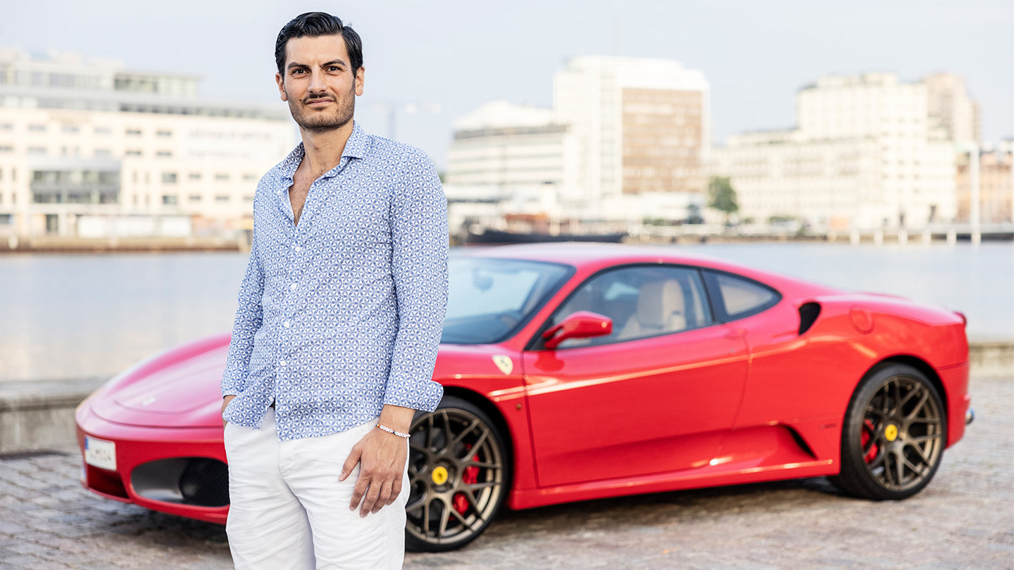 Tamer Senyüz står framför sin röda Ferrari