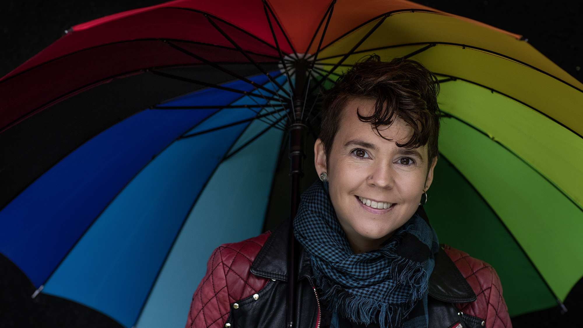 Sara Lövestam med ett regnbågsfärgat paraply.