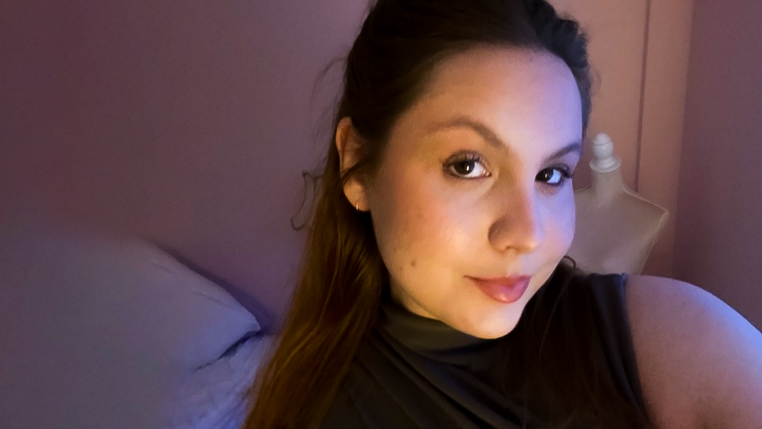 Ung kvinna tar en selfie och tittar in i kameran