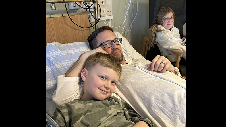 En man på sjukhus med sin familj