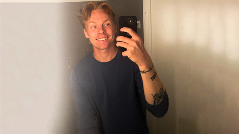Ung glad man tar en selfie i en spegel