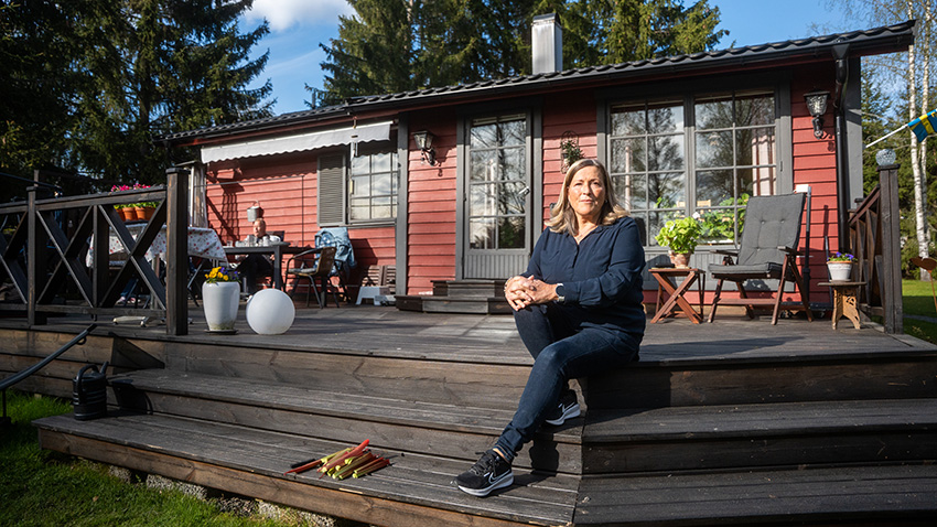 Lotta Eisner i mörkblå blus på trappen upp till altanen vid hennes lantställe strax utanför Köping. 