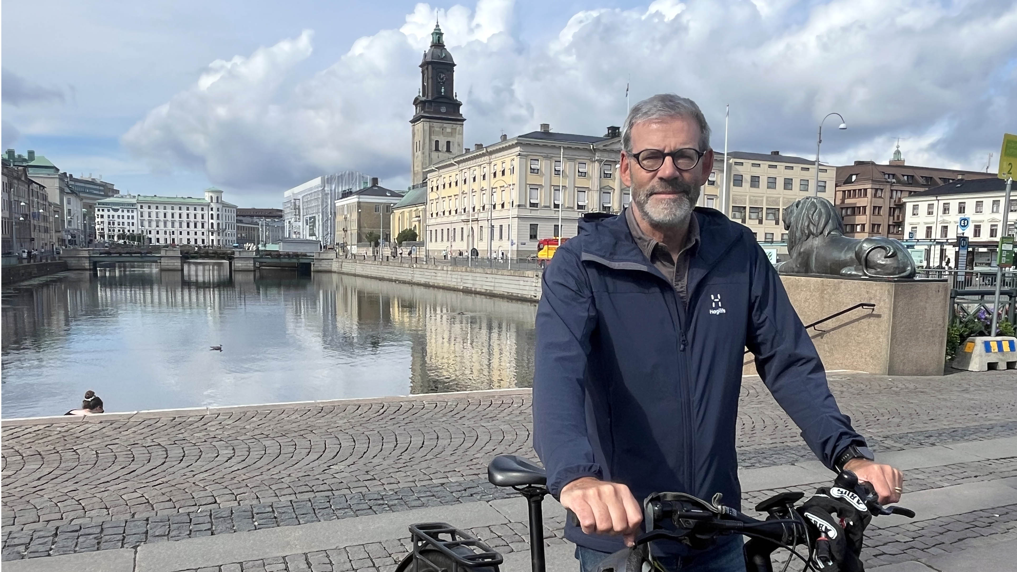 man vid cykel framför Göteborgsmiljö