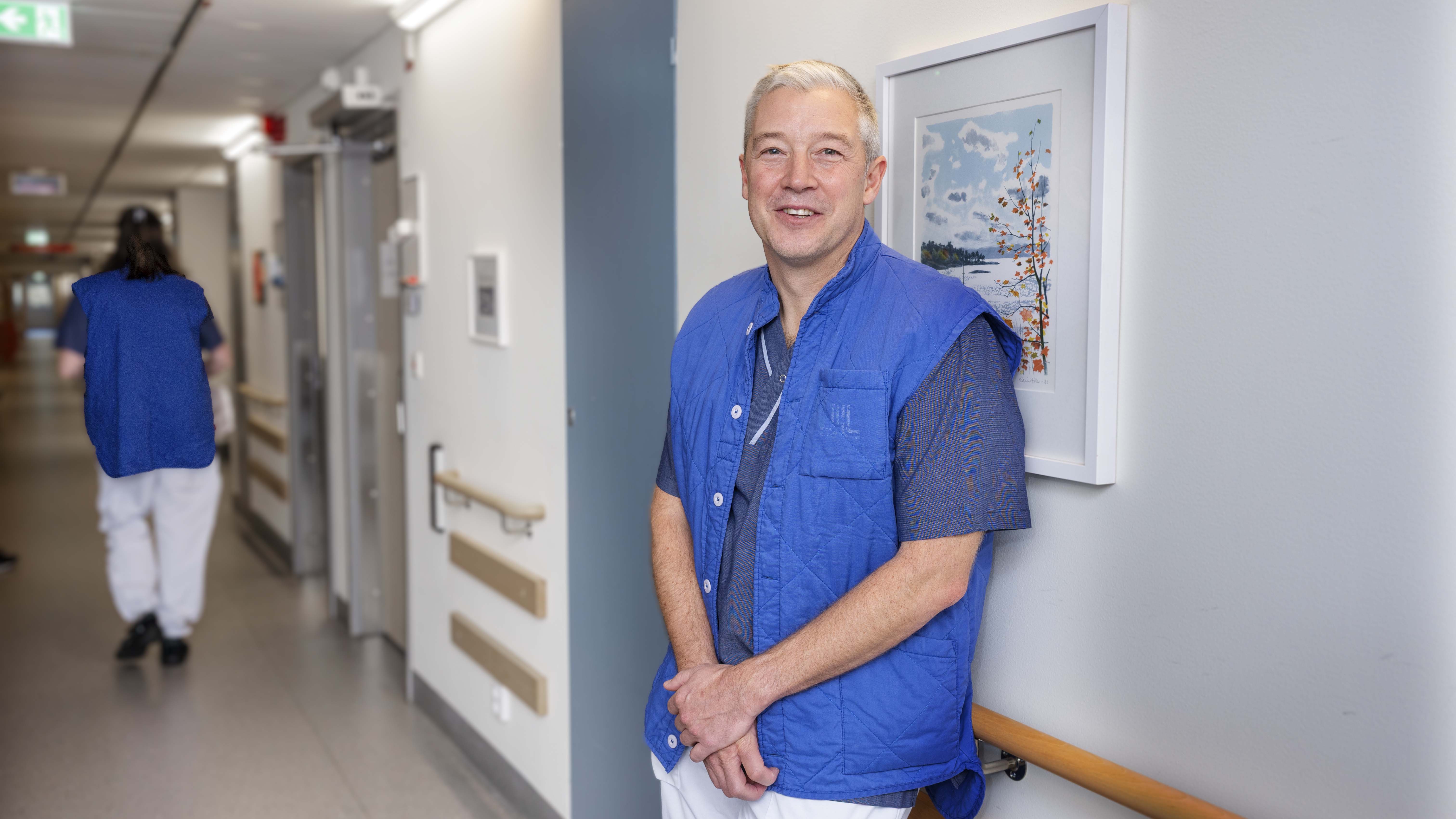 man i sjukhusklädsel i sjukhuskorridor