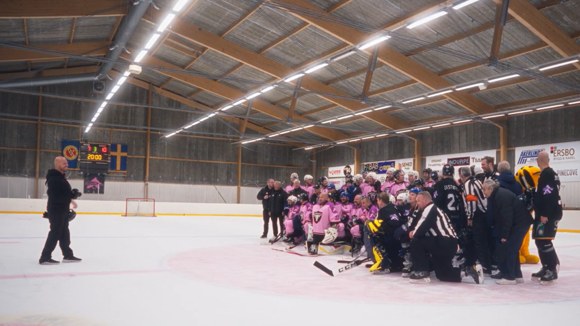 en gruppbild på två hockeylag på isen efter avslutad match. 