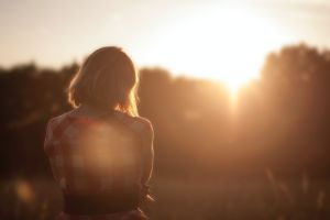 Woman looking out to morning sunshine