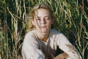 A lady sitting in long grass