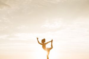 Woman in yoga pose with sun
