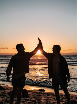 Men high fiving on beach