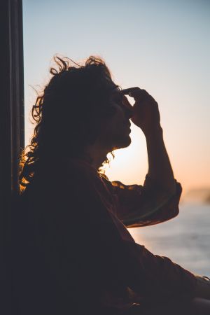 Woman looking outside window in pain