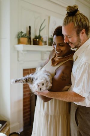 Couple smiling holding cat at christmas