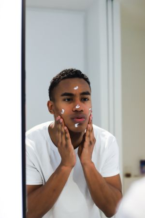 Man applying skin cream to face