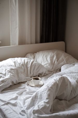 Unmade bed with cofeee