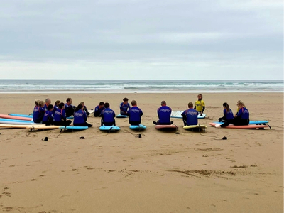 Several people sat on surfboards during a surfing lesson on the beach