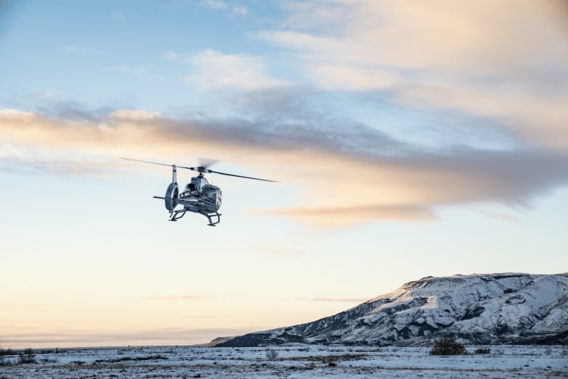 Image of a helicopter flying in Iceland with tourists.