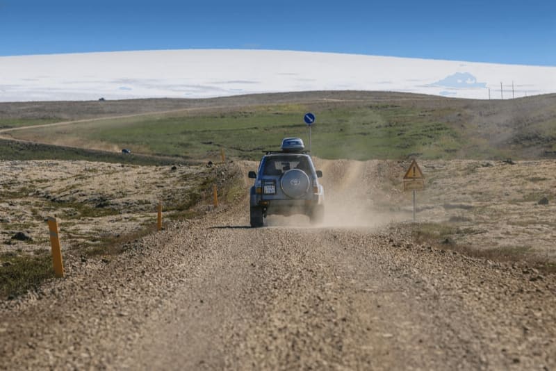Image of a vehicle driving on a gravel road
