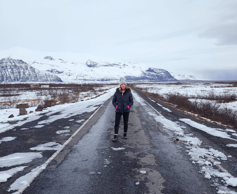 Image of a tourist traveling in Iceland, standing outside on a snowy icy road.