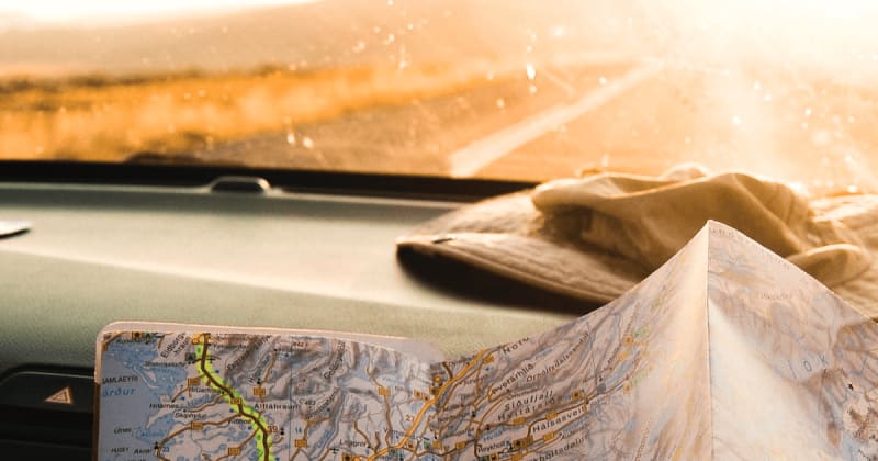 Image of a person holding a map inside a rental vehicle in Iceland.