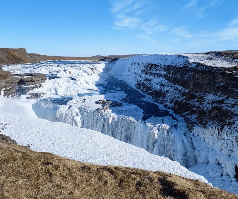 Image of Gullfoss in Iceland with snow and ice on a sunny day
