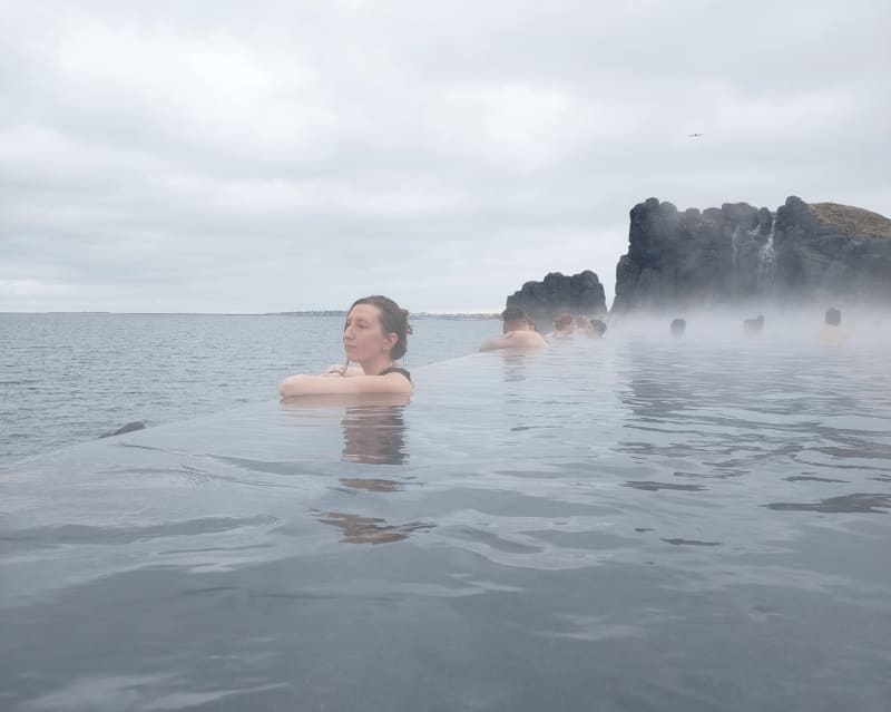 Image of travelers bathing in the infinity pool of the Sky Lagoon in Iceland