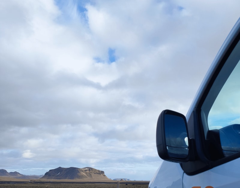 Image of the side of a campervan rental in Iceland, with great views.