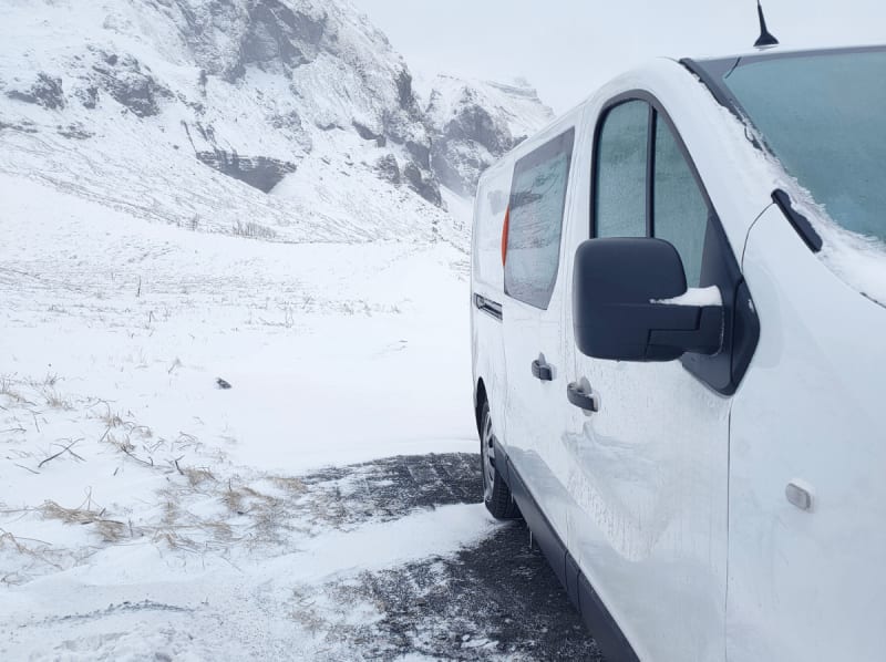 Image of a campervan parked in the wintertime in Iceland, snow on the ground.