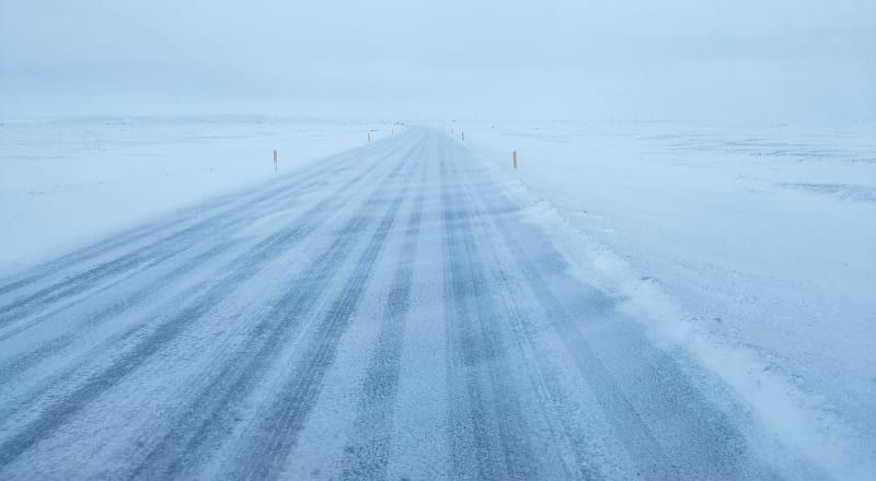 Image of a snowy and icy road in Iceland with harsh conditions to drive.