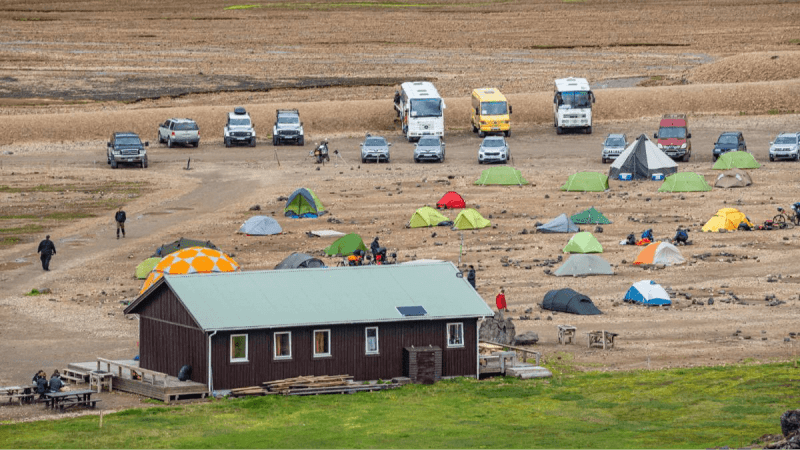Image of a campsite in Iceland that is busy and has many tents and parked campervans.