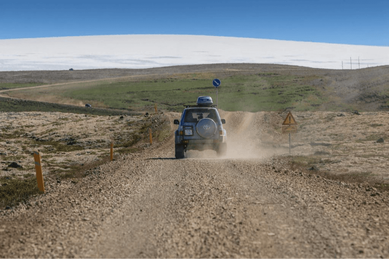 Image of a rental vehicle driving on a gravel road in Iceland