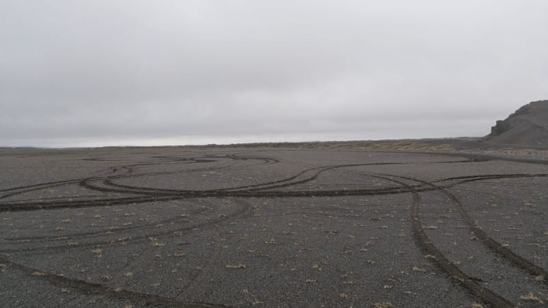 Image of tire marks where someone has driven off road in Iceland, that is illegal