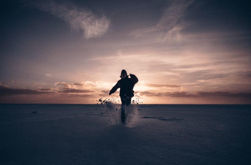 A man playing in the snow and sunset in Iceland