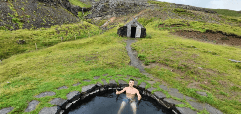 Image of a person sitting in a geothermal pool Gudrunarlaug