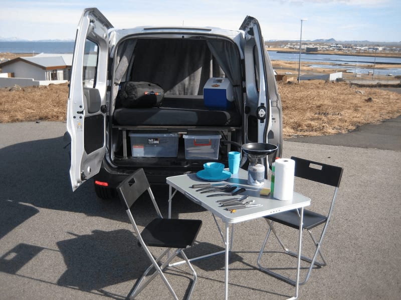Image of a camping chair and table with cooking equipment