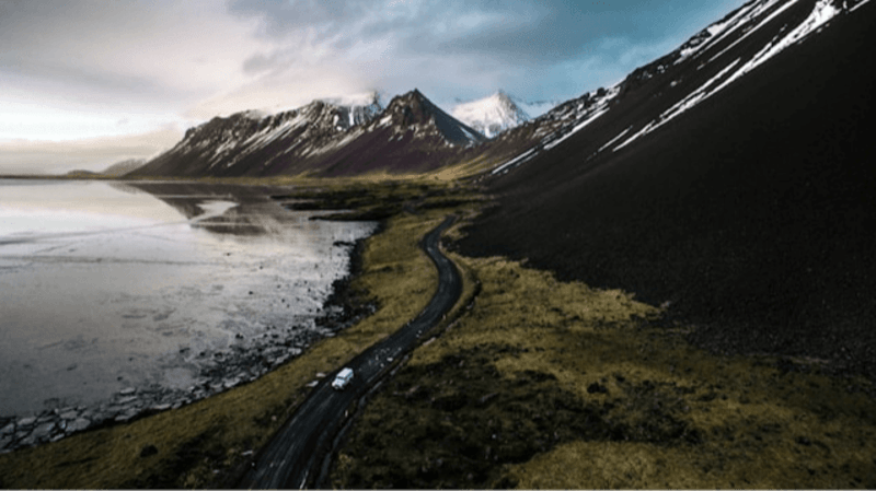 Image of Iceland and a car driving in the highlands and fjords