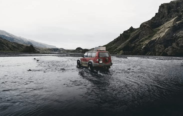 An image of an 4x4 truck crossing a river in Iceland, while driving on an F-Road.
