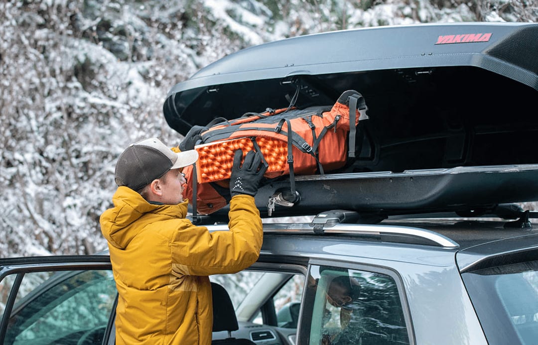 Image of a traveler in Iceland loading the cargo box on top of this Iceland 4x4 Rental Car