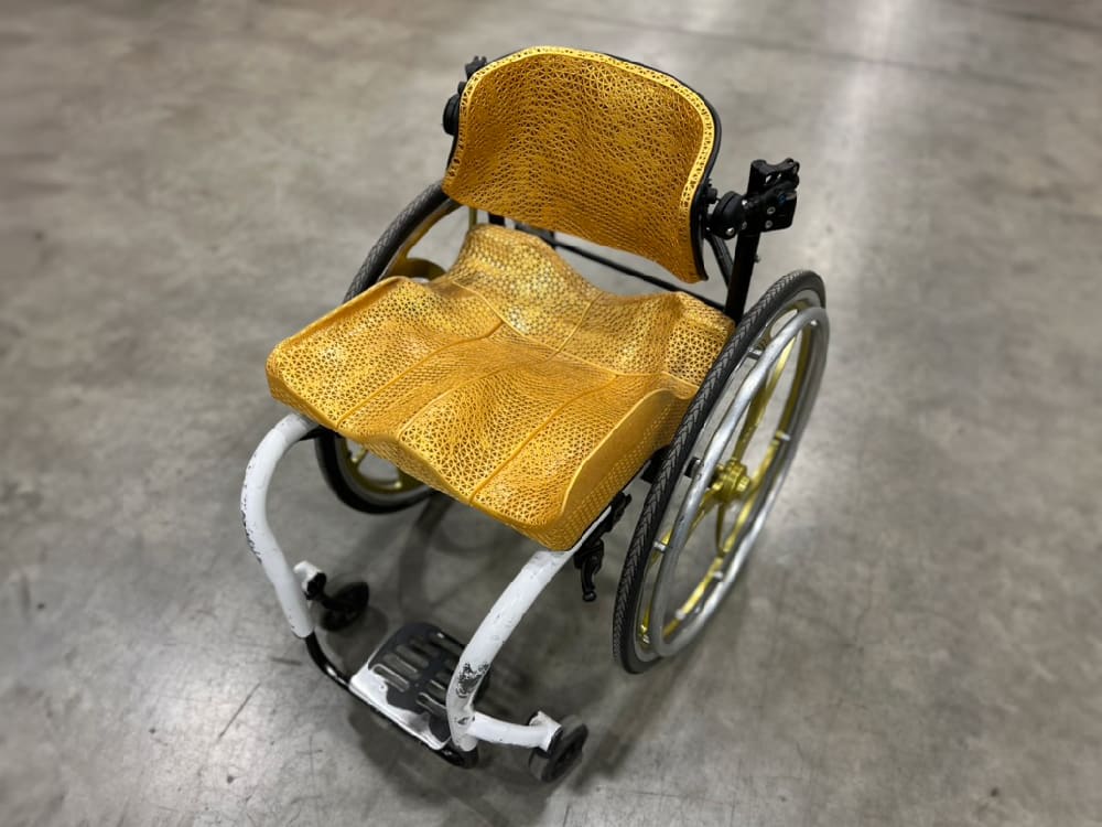 A wheelchair with customized gold padding by Tarkka